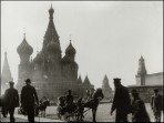 The ornate domes of St Basil's in the background with two horse and carts and several pedestrians in the foreground