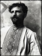 Head and torso self-portrait of Mucha dressed in a traditional Czech shirt looking out to the right of the camera