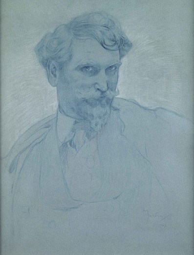 Head and shoulders portrait of the artist with a beard leaning his head to his left while looking upwards towards the viewer