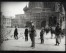 Mucha standing in the middle of the square sketching with boys looking on and St. Basil's cathedral behind