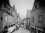 Prague 1900 A narrow street scene with shops and pedestrians