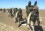 U.S. Marines in Southern Afghanistan Armed soldiers in uniform carrying large back packs and ammunition walk across an arid landscape