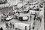 Car Barricades in Paris in May, 1968 A street scene seen from above with cars turned on their sides and people standing around