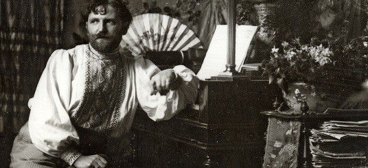 Mucha in his studio (crop) Mucha in his studio dressed in an embroidered smock, seated and leaning on a piece of furniture