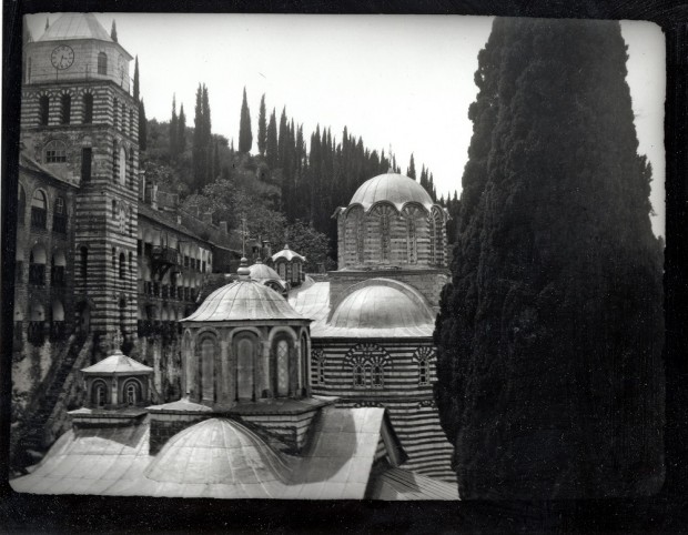 The domes and towers of the monastery seen from a height with a large fir tree to the right