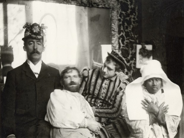 Mucha stands next to Gauguin who wears a decorated hat, Marold who is dressed in a stripey suit, and Anna who wears a Breton headdress